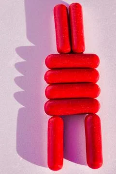 Creative arrangement of red candy sticks on a pink background. Stock Photos