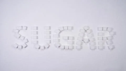 Creative arrangement of sugar cubes forming the word sugar on a white background Stock Photos