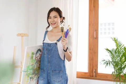Creative of art concept, Young asian woman holding paintbrush and artwork aft Stock Photos