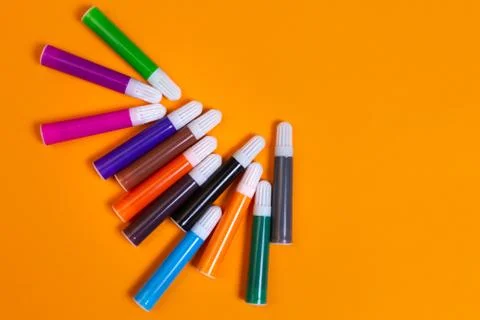 Creative art design with multi colored markers on yellow background Stock Photos