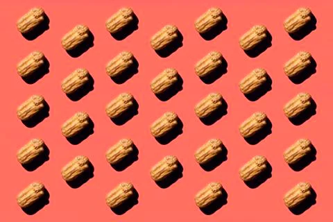 Creative art with yellow Eclair pattern on coral background.Isometric flat la Foto stock