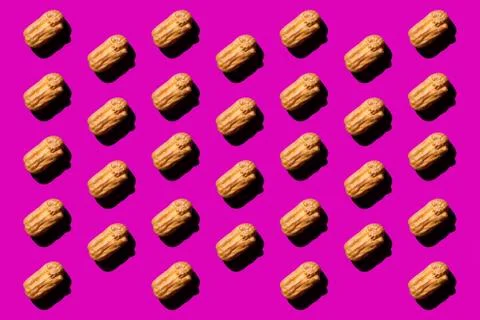 Creative art with yellow Eclair pattern on purple background.Isometric flat l Stock Photos