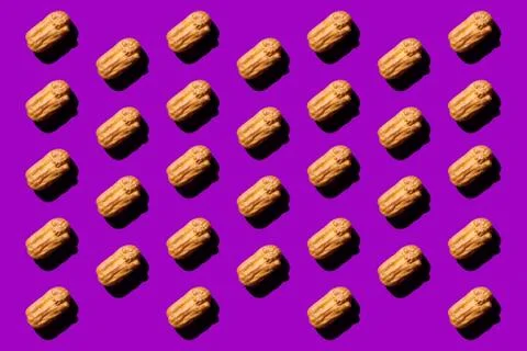 Creative art with yellow Eclair pattern on purple background.Isometric flat l Stock Photos