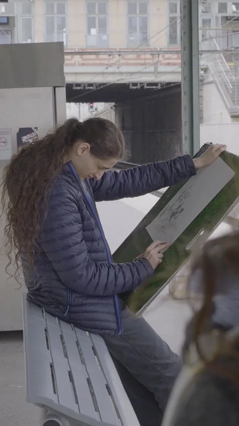 Creative Artist Sketching at Bustling Train Station on a Bench Stock Footage 319467587