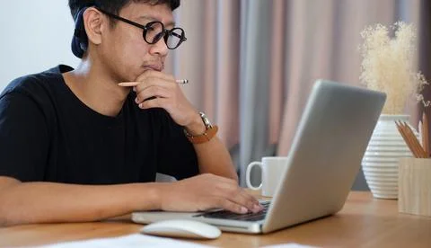 Creative asian man working with computer laptop at modern workplace. Stock Photos