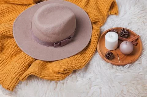 Creative autumn composition with hat, yellow sweater and candles Stock Photos
