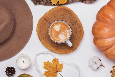 Creative autumn flat lay with cup of coffee, yellow leaves and hat Stock Photos