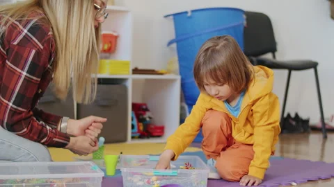 A creative babysitter plays a fun game with a little boy in the car, keeping him Stock Footage 272531333