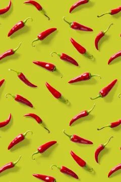 Creative background made of red chili or chilli on green backdrop. Minimal food Stock Photos