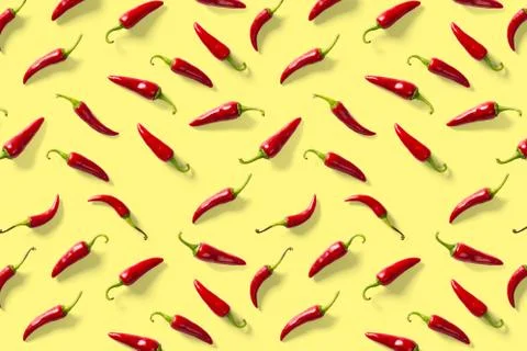 Creative background made of red chili or chilli on yellow backdrop. Minimal food Stock Photos