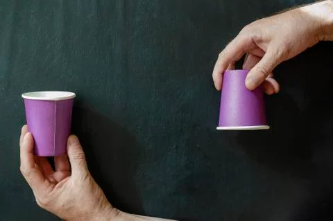 Creative background with paper cups for hot drinks and a man's hand. Stock Photos