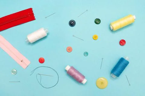 Creative background with sewing accessories: threads, buttons, and needles. Home Stock Photos