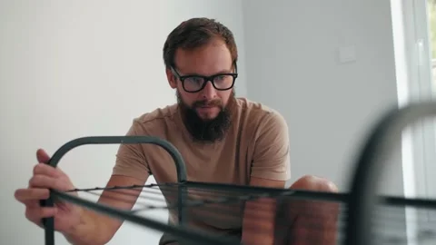Creative bearded man fixing details metallic shelf shoes storage construction Stock Footage 233469794