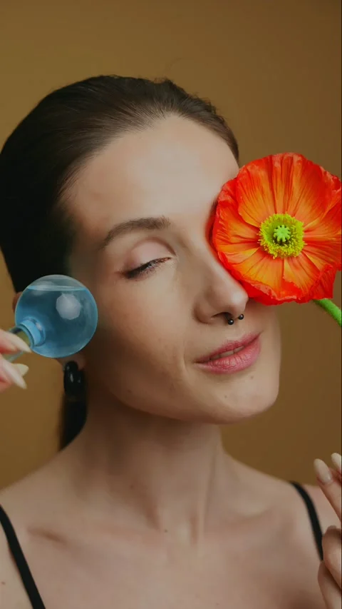 Creative beauty routine featuring floral elements and skincare tools 動画素材 305393619