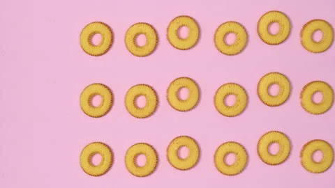 Creative biscuits appear on pastel pink background. Stop motion 스톡 동영상 190482746