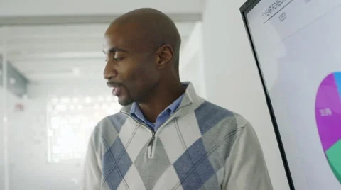 Creative black businessman talking about pie chart in meeting Stock Footage 67003132