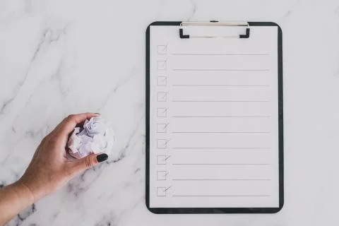 Creative block or burnout, to do list on clipboard and hand holding scrunched Stock Photos
