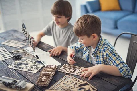 Creative boy holding pliers while his friend looking at the pattern Stock Photos