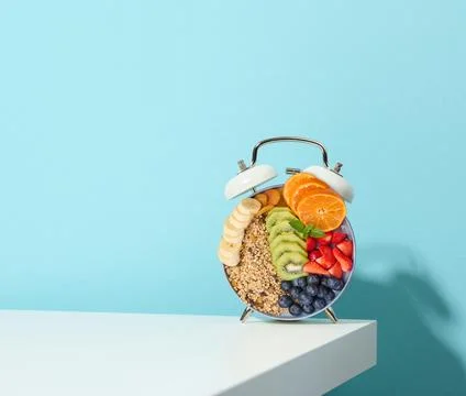A creative breakfast in the shape of an alarm clock with fruits and cereals.. Foto stock