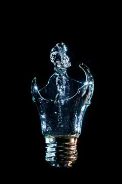 Creative broken light bulb with water fountain on isolated black background w Foto stock
