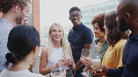 Creative business colleagues celebrating with drinks on a balcony in the city Stock Footage
