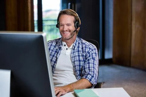Creative businessman smiling while working on computer 写真素材
