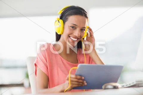 Creative Businesswoman Smiling At Camera And Listening Music