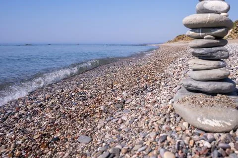 A creative cairn made out of flat rocks erected with balance at the water's e Stock Photos
