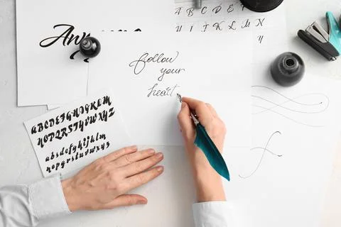 Creative calligraphy art with feather pen and ink, hand lettering practice, i Stock Photos