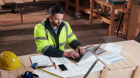 Creative, carpenter and man with laptop in workshop, research and planning for Stock Footage 338315751