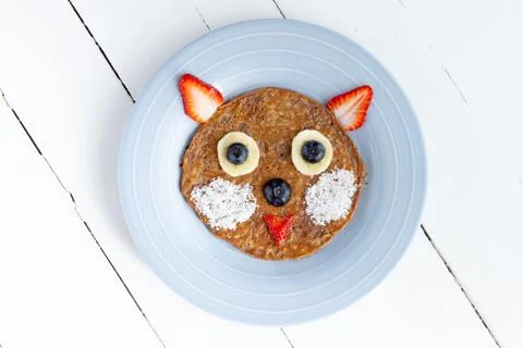 Creative cat pancake for kids in a plate isolated on white background. Stock Photos