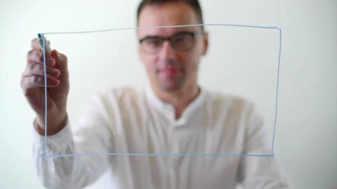 Creative caucasian guy having fun while drawing on a glass board Stock Footage 236958187