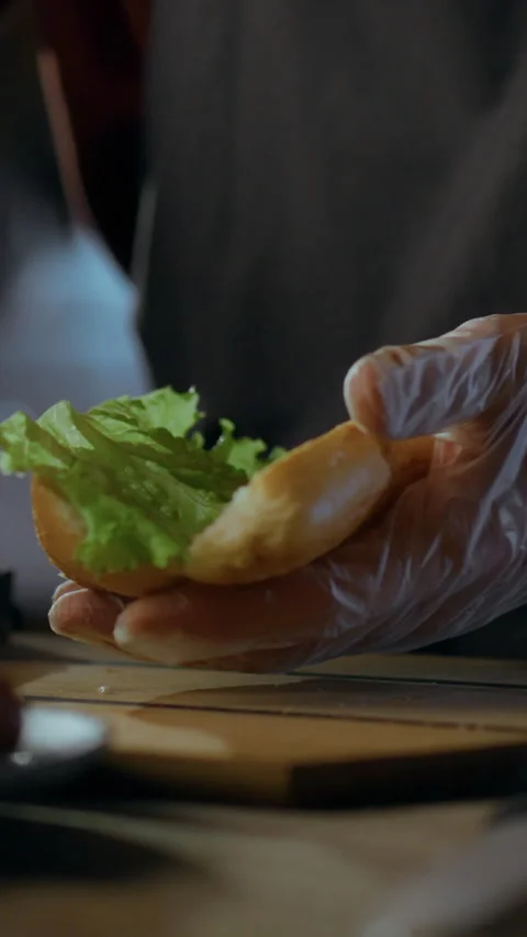 Creative chef prepares a delicious hot dog with fresh ingredients in a livel Stock Footage 331541512