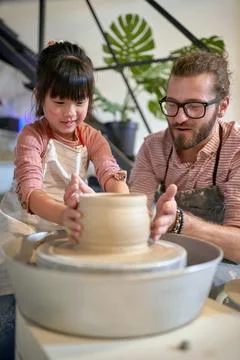 Creative child and teacher making pot from clay with hands in pottery hands.. Stock Photos