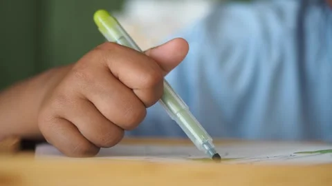 Creative child drawing with a pen in classroom setting Stock Footage 313105932