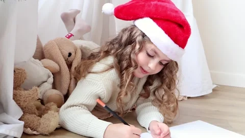 Creative child in festive hat dreaming up artwork by cozy corner Stock-Footage 296324380