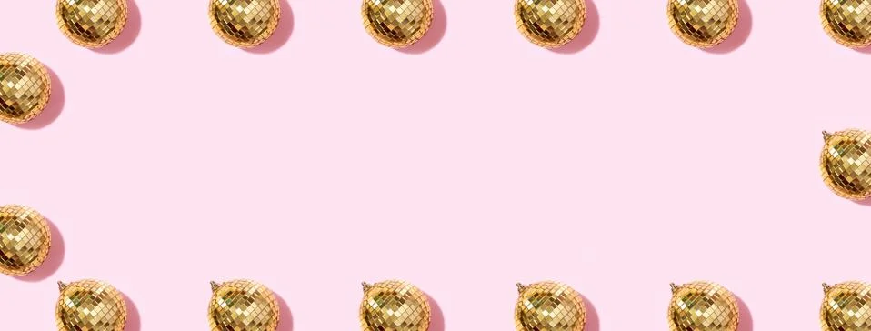 Creative Christmas pattern. Frame with shiny gold disco balls over pink Stock Photos