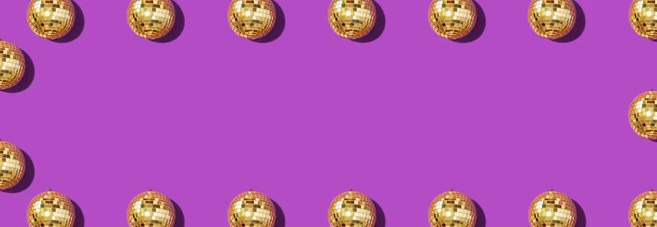 Creative Christmas pattern. Frame with shiny gold disco balls over violet Stock Photos