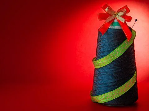 Creative Christmas tree made from coil of green threads on red paper backgrou Stock Photos