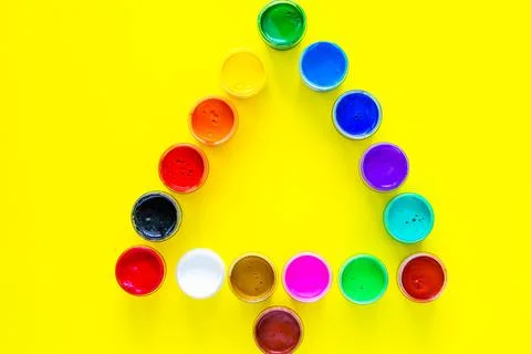 Creative Christmas tree made of paint cans on a yellow background. top view Stock Photos