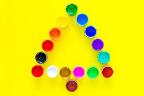 Creative Christmas tree made of paint cans on a yellow background. top view Stock Photos