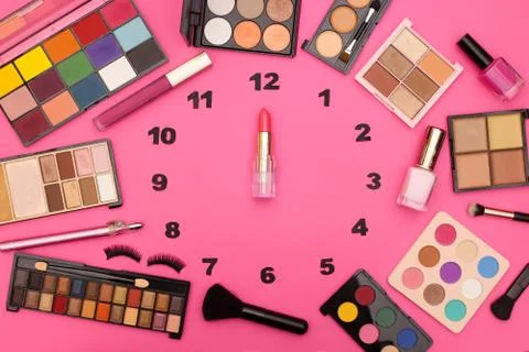 Creative clock made of make up and cosmetics products with lipstick clock wise Stock Photos