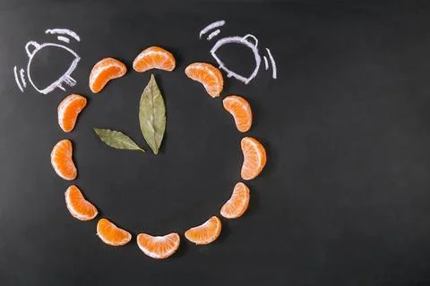 Creative Clock Made of Tangerine Slices on Blackboard Stock Photos