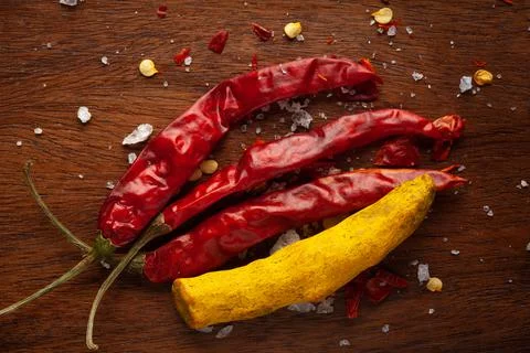 Creative close-up composition of red Chili pepper and dry yellow turmeric roo Stock Photos