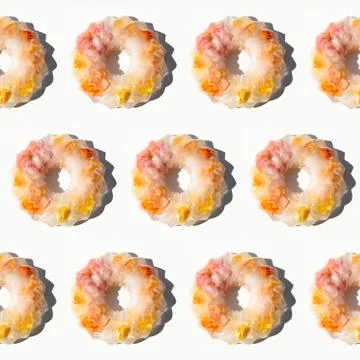 Creative colorful fruit pattern of frozen roses in ice on white background Stock Photos