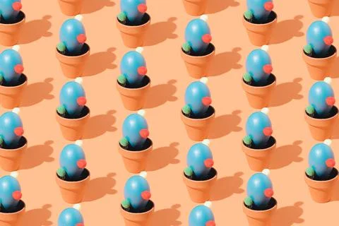 Creative colorful pattern of blue cactus shaped eggs in a flower pots on a br Stock Photos