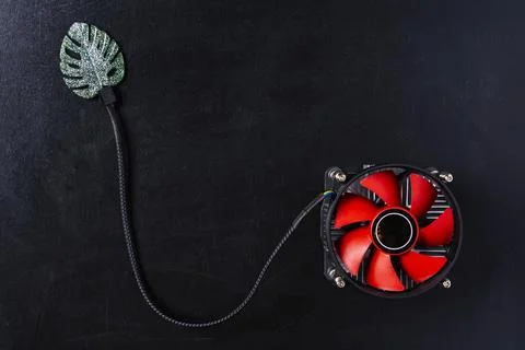Creative composition, computer cooler connected to a green leaf on a black ba Foto stock