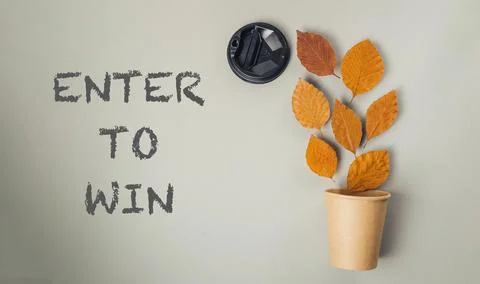 Creative composition featuring autumn leaves in a paper cup with camera lens and Foto stock