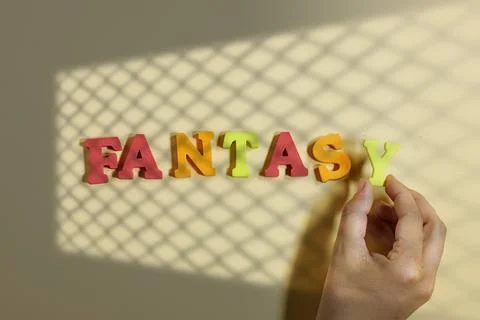 Creative Composition Featuring Colorful Foam Letters Spelling Fantasy with Hands Stock Photos