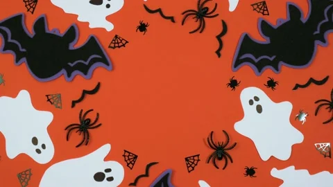 Creative composition of Halloween decorations rotates on an orange background.4k Stock Footage 217673240